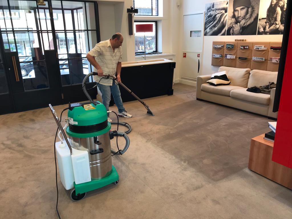 Werknemer die tapijt reinigt bij een klant